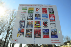 900741 Afbeelding van een tijdelijk verkiezingsbord met affiches van de politieke partijen die meedoen aan de ...